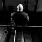 Homem sentado no banco do supino